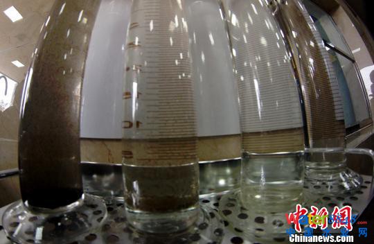 工廠水處理中心展示臺前展示出的污水和經(jīng)過三次處理后的水。　王昊陽 攝